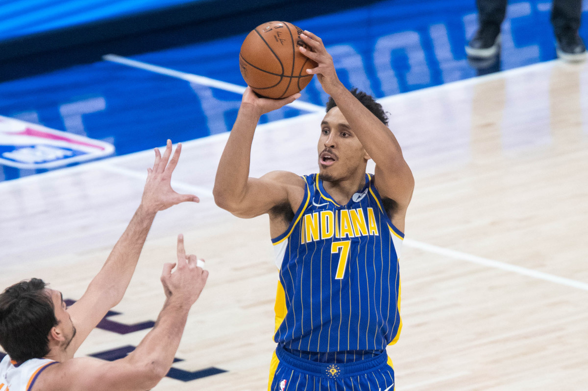 Jan 9, 2021; Indianapolis, Indiana, USA; Indiana Pacers guard Malcolm Brogdon (7) shoots the ball over Phoenix Suns forward Dario Saric (left) in the third quarter at Bankers Life Fieldhouse. Mandatory Credit: Trevor Ruszkowski-USA TODAY Sports